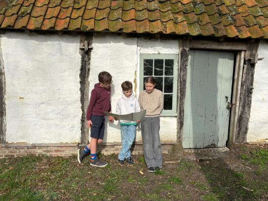 3 kinderen kijken naar de kaart van expeditie droomthuis 