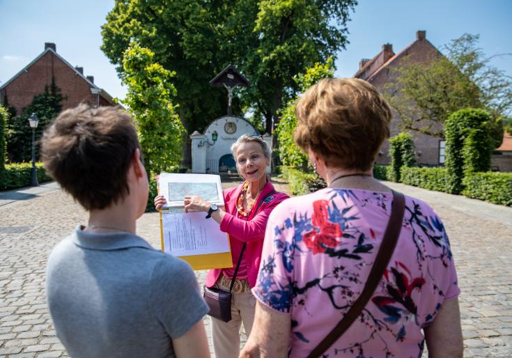 Gids die een uitleg doet in het begijnhof