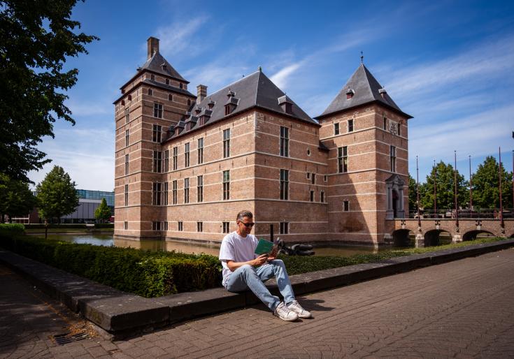 Man die een boekje leest voor het kasteel