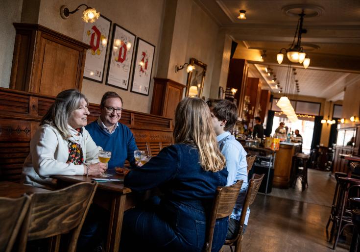 Gezin dat op café geniet van een glas bier