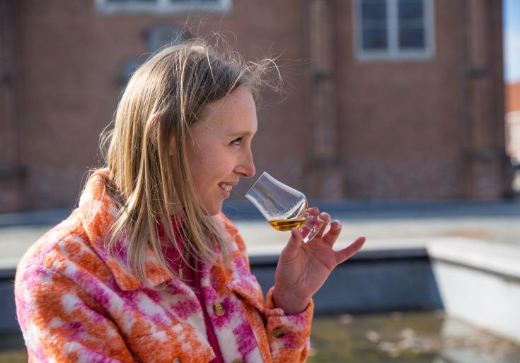 Vrouw die van een proevertje whisky drinkt