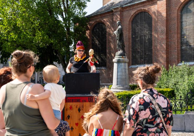 Gezin met kinderen kijkt naar een poppenspel